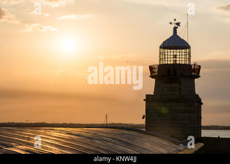 Ciel Coucher de soleil orange chaud sur Howth Irlande lighthouse tower Banque D'Images