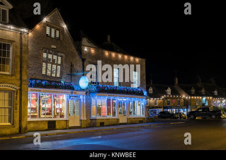 Huffkins bakery et salons de thé à la place du marché avec des décorations de Noël dans la nuit. Stow on the Wold, Cotswolds, Gloucestershire, Angleterre Banque D'Images