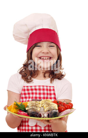 Happy little girl cook avec de la truite sur la plaque Banque D'Images