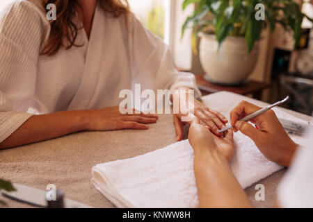 Femme qui reçoit une manucure. Mains de nail technician client donnant une manucure au salon de beauté. Banque D'Images