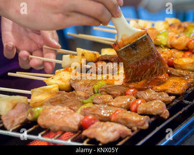 Thai Satay porc homme vend barbecue - viande de porc frit sur des bâtons. Banque D'Images