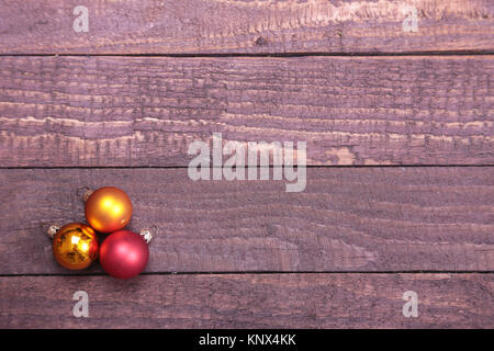 Trois boules de Noël sur fond de bois isolé Banque D'Images