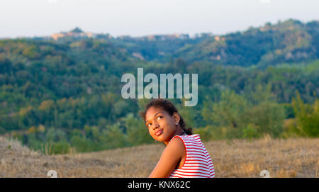 Les jeunes touristes afro-américaine avec délicieux blanc et rouge robe jupe rouge admire le paysage toscan pendant le coucher du soleil Banque D'Images