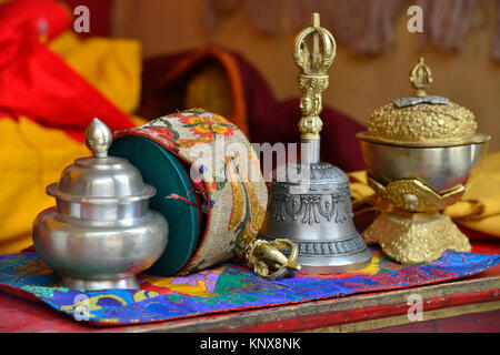 La prière de table un moine bouddhiste : un rituel bell, un tambour, un bol sont prêts pour une puja dans un monastère. Banque D'Images