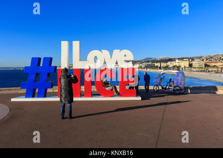 Les personnes qui prennent des photos de la 'J'aime Nice' hashtag signe, qui est apparu pour la première fois dans le centre de Nice après les attaques terroristes et s'élève maintenant sur la promena Banque D'Images