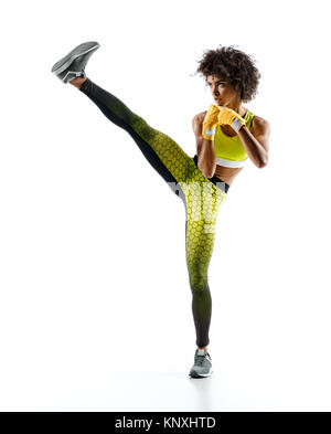 Girl practicing tae-bo d'exercices, des coups de l'avant avec les jambes. Photo de fille africaine sportive portant des vêtements de sport sur fond blanc Banque D'Images