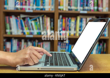 Part de la saisie sur ordinateur portable sur la table de bois dans la bibliothèque, de l'éducation Technologie concept Banque D'Images