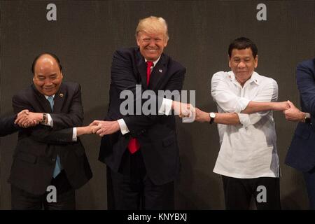 Le Président américain Donald Trump, centre, tient la main de la présidente philippine Rodrigo Duterte, droite, et Premier ministre vietnamien Nguyen Xuan Phuc, au cours de la photo de groupe des dirigeants pour la cérémonie d'ouverture du sommet de l'ASEAN au Philippine International Convention Center le 13 novembre 2017 à Pasay City, Manille, Philippines. Banque D'Images