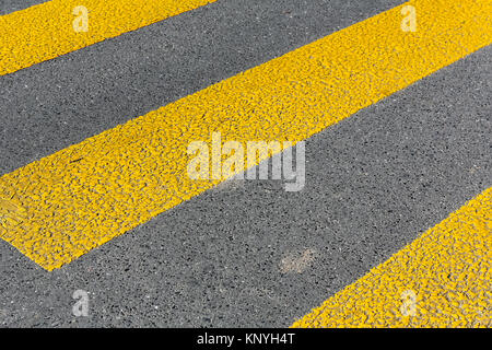 Un signe sur la route marquée d'un zèbre protège les gens qui traversent la rue. Banque D'Images