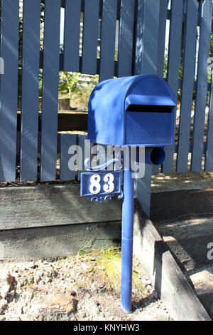 Boîte aux lettres bleu à Brisbane en Australie avec trou pratiqué dans la clôture pour la récupération de Mail Banque D'Images