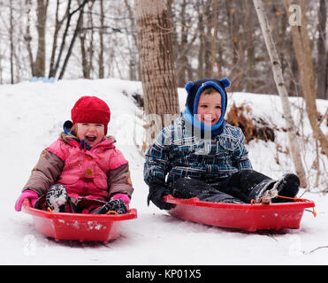 Frère et soeurs (5 et 3 ans) de la luge au Québec en hiver Banque D'Images