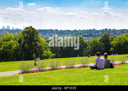 Couple sitting in Alexandra Palace Park à la recherche au niveau de la vue de la ville de Londres dans la distance, London, UK Banque D'Images