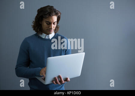 Jeune male executive using laptop in office Banque D'Images