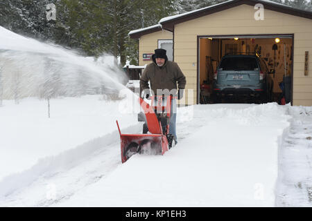 L'homme l'exploitation d'une souffleuse à neige pour enlever la neige profonde de son allée après une tempête hivernale dans la région de spéculateur, NY, New York, USA Banque D'Images