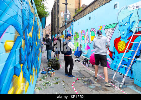 Les artistes de rue Graffiti les murs de pulvérisation en Fleur Street, London, UK Banque D'Images