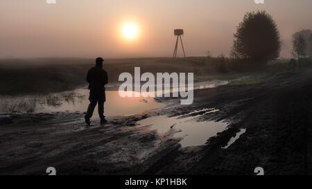 Heure du lever silhouette humaine à côté de chemin boueux en Pologne, Biebrza Banque D'Images