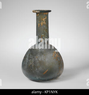 Ce flacon de parfum en verre romain du 1er au 2ème siècle après J.-C. est incolore avec une teinte verdâtre. Il dispose d'un rebord replié, sur et dans, avec un col cylindrique et un corps incliné, caractéristique des bouteilles de parfum romaines. Banque D'Images