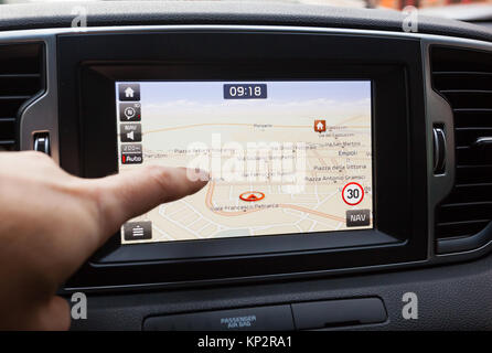 Panneau de navigation GPS sur le tableau de bord à l'intérieur d'une voiture. Pointer du doigt le point de destination. Banque D'Images