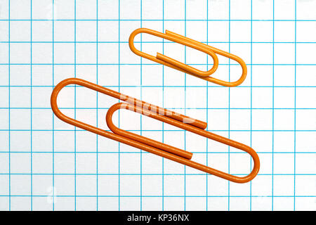 Orange deux trombones sur une feuille de grille Banque D'Images