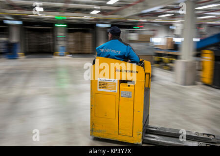 Zehdenick, Allemagne. 13 Décembre, 2017. Un employé conduit un chariot élévateur à travers le nouveau centre logistique de Hermes Ketzin, Allemagne, 13 décembre 2017. L'entreprise prévoit tripler sur sa capacité avec le nouveau bâtiment dans la grande région de Berlin. Sur quelque 80 000 mètres carrés jusqu'à 250.000 colis sont à traiter chaque jour. Le paquet d'exécution visent à réduire, quelque 200 places de travail sont créées. Crédit : Paul Zinken/dpa/Alamy Live News Banque D'Images