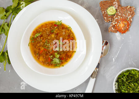 Soupe de quinoa péruvien, riz rouge et lentilles dans une plaque blanche avec des herbes et des biscottes. La nourriture végétalienne saine concept. Banque D'Images