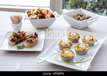 Tapas : bruschetta, morsure douce quiche de taille moyenne, de fromage et d'olive et mélanger champignons marinés. Banque D'Images