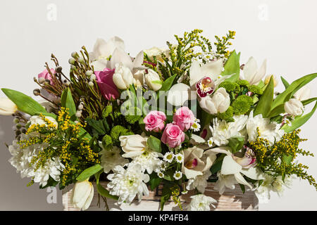 Composition de fleurs de roses, orchidées blanches, tulipes rouges, jacinthe et hrzemtem. Arrangement floral dans une boîte pour une fille de roses, tulipes et Banque D'Images