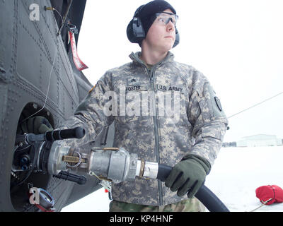 Le sergent de la Garde nationale de l'Armée de l'Alaska. Cody Foster, un spécialiste de l'approvisionnement en pétrole avec e compagnie, 1er Bataillon, 207e Régiment d'aviation, ravitaille un 1-207e UH-60 Black Hawk Aviation le 2 décembre 2017, Bryant Army Airfield sur Joint Base Elmendorf-Richardson, en Alaska. L'UH-60 utilise du carburant JP-8, qui est le même carburant utilisé pour l'équipement au sol. (U.S. La Garde nationale de l'armée Banque D'Images