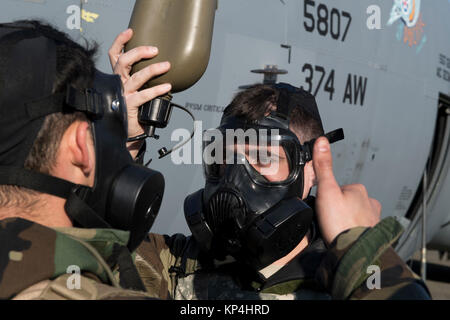 Aviateurs, avec le 374e Escadron de maintenance effectue des vérifications pour s'assurer qu'ils peuvent recevoir de l'eau par leur composition chimique, biologique, radiologique et nucléaire d'équipement de protection au cours de l'exercice Vigilant Ace 18, le 6 décembre 2017, à Yokota Air Base, le Japon. L'initiative de contrôles sont d'assurer l'équipement de protection fonctionne correctement et si les aviateurs peuvent rester hydraté tout en travaillant dans des conditions potentiellement contaminés. (U.S. Air Force Banque D'Images