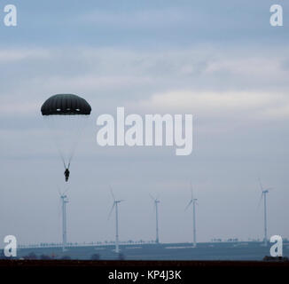 Un parachutiste dérive vers le bas sur le sol après avoir réussi un saut lors de la 5e théâtre Quartier-maître la livraison aérienne de l'opération annuelle de l'entreprise chute Jouet du 5 décembre. Les soldats, aviateurs, et allié et les pays partenaires se sont réunis pour la semaine pour offrir des cadeaux à des familles locales et renforcer des alliances. (U.S. Army Banque D'Images