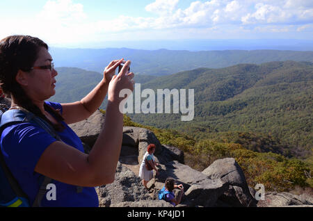 Woman taking photograph lors du sommet de la montagne, le Sharp Top Peaks Of Otter, les montagnes Blue Ridge, Virginia, USA Banque D'Images