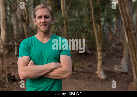 Portrait de jeune homme randonneur avec plié mains debout dans la forêt lors d'une journée ensoleillée Banque D'Images