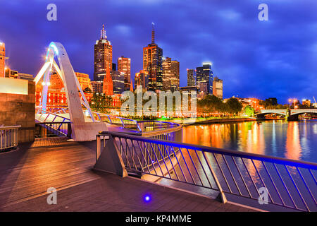 La ville de Melbourne CBD waterfront se reflétant dans les eaux de la rivière Yarra Walker pont pied dark avant le lever du soleil. Banque D'Images