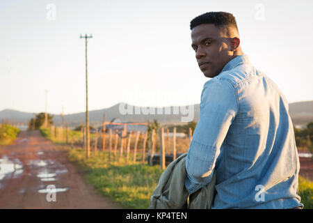 Portrait de l'homme marchant sur un chemin de terre à campagne Banque D'Images