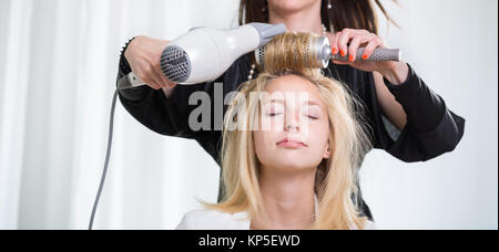 Jolie jeune femme ayant les cheveux faites par un professionnel, hairstylist Banque D'Images