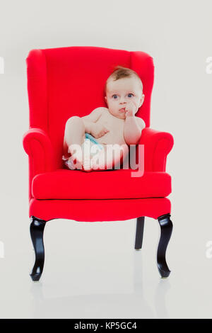 Bébé, 4 Monate, sitzt auf einem roten Stuhl - bébé assis sur une chaise rouge Banque D'Images