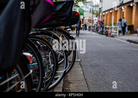 Les vélos garés dans une ligne sur une rue latérale à Shinjuku, Tokyo, Japon Banque D'Images