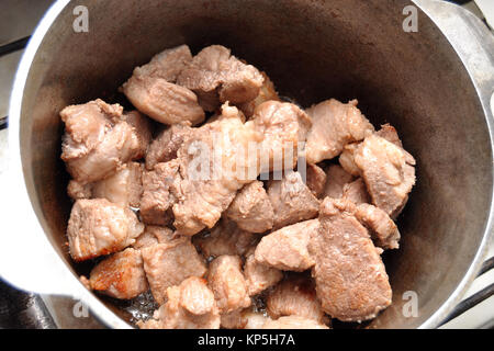 Processus de ragoût de porc dans une casserole en fonte. Close-up, vue du dessus. Banque D'Images