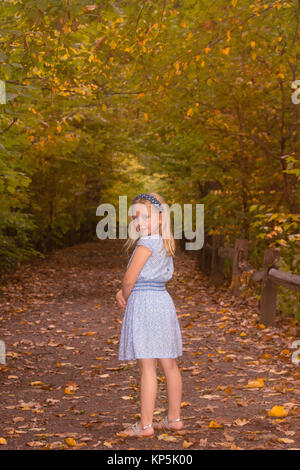 L'âge scolaire adorable fille qui marche en forêt en automne, saison d'automne Banque D'Images