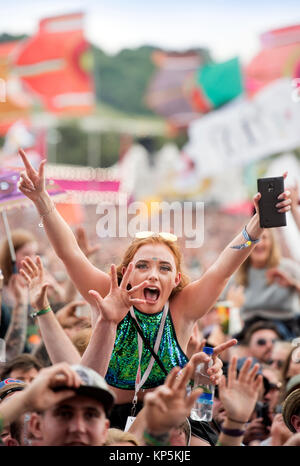 Une jeune femme danse du ventilateur comme Liam Gallagher joue sur l'autre étape, Glastonbury 2017 Banque D'Images