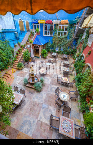 Cour avec terrasse colorée pleine de décorations et des murs couverts de plantes Banque D'Images