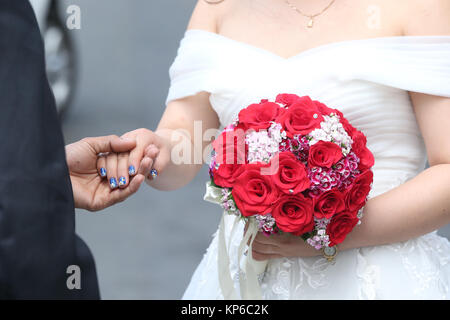 Mariage. Bride holding bouquet de roses. Ho Chi Minh Ville. Le Vietnam. Banque D'Images