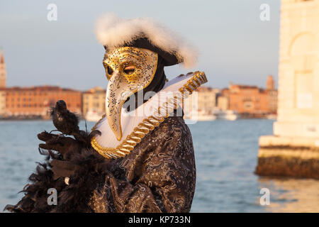 Carnaval de Venise, Vénétie, Italie 2017 Peste médecin avec bec et d'oiseaux au coucher du soleil masque au lagoon Banque D'Images
