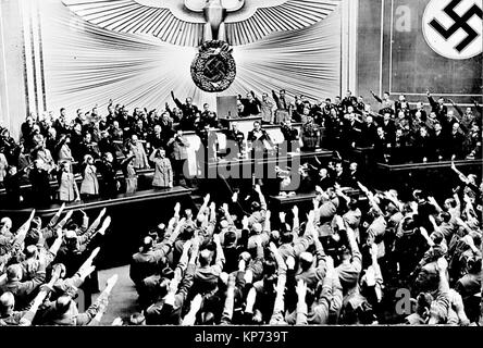 Hitler accepte l'ovation du Reichstag après l'annonce de l'acquisition de "rétablissement de la paix" de l'Autriche. Elle a ouvert la voie à l'annexe la région des Sudètes en Tchécoslovaquie, en grande partie habitée par une population de langue allemande. Berlin, mars 1938. Banque D'Images