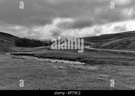 Une route sinueuse (B6278) menant à travers les collines dans Weardale dans le comté de Durham, sur un jour de tempête en mars. Banque D'Images