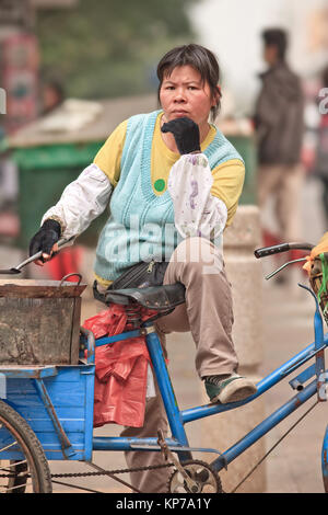 GUANGZHOU-déc. 13, 2009. De vendeurs d'aliments de la rue de sexe féminin. Au cours des dernières années, de nombreuses villes chinoises a réprimé ses vendeurs de rue. Banque D'Images