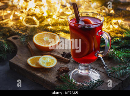 Vin chaud avec des épices et l'arbre de Noël sur fond de bois. Banque D'Images