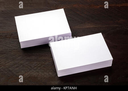 Une photo de la maquette blanche deux piles de cartes d'affaires sur une texture de fond en bois foncé, un modèle de présentation avec une place pour le texte Banque D'Images