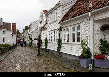 STAVANGER, Norvège, le 03 juillet 2010. Vue d'une rue avec des bâtiments en bois. Des personnes non identifiées autour. La pluie. Usage éditorial. Banque D'Images