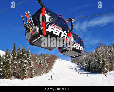 Jasna, Slovaquie - Décembre 01, 2017 : deux cabines de la téléférique et les skieurs sur la pente de ski du mont Chopok côté sud sur une journée ensoleillée dans le sk Banque D'Images